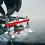 Repair work on cracked car windshield closeup. Fixing cracks in window