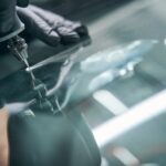 Service worker check crack on car window closeup. Windshield repair